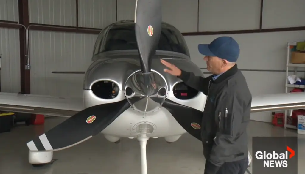 Capture d'écran d'un journal télévisé diffusé sur Global News. Un homme se tient devant un petit avion et montre son hélice.