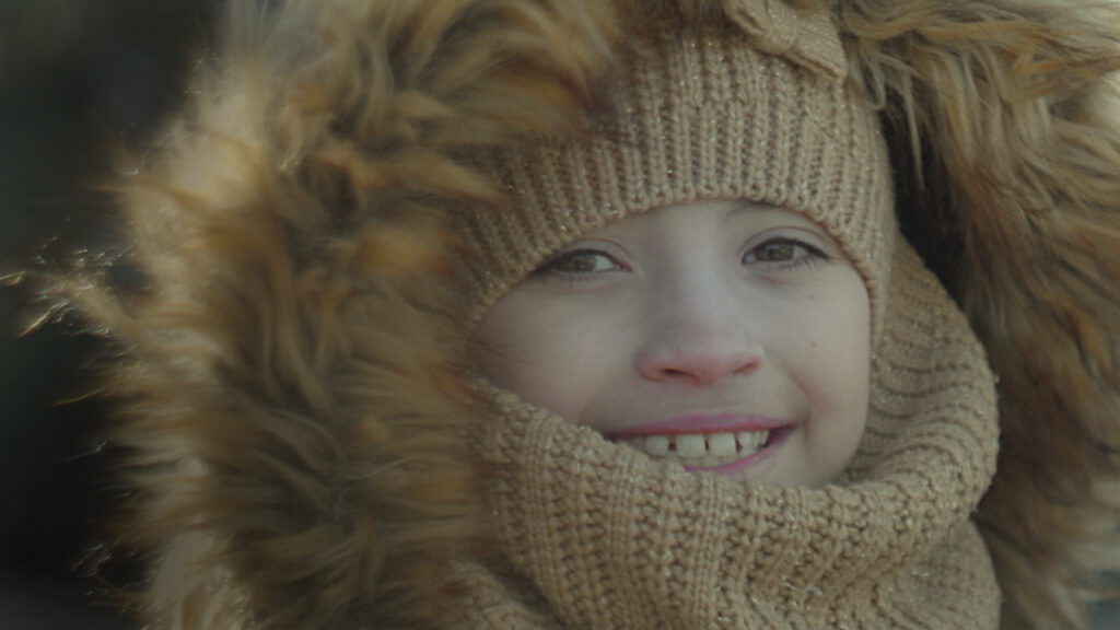 close up of a young girl in winter gear, smiling