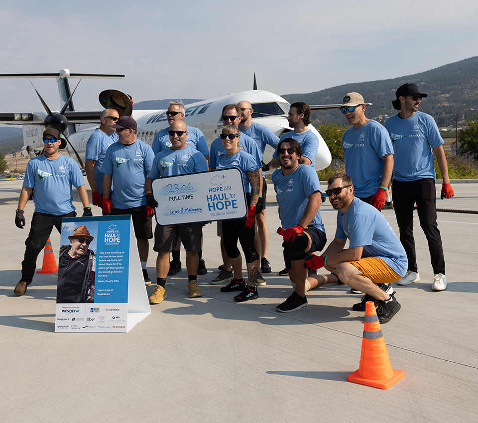 A group of people in blue shirts standing holding a sign of 23 minutes pull time for Haul for Hope