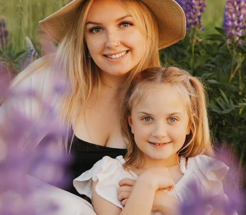 Une mère et sa fille souriant à l'appareil photo dans un champ de lavande